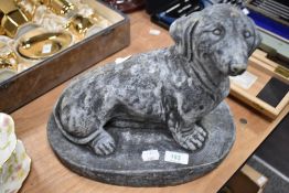 A concrete Dachshund garden ornament.
