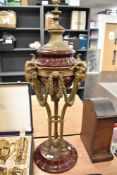 An impressive large Victorian style ceramic and brass lamp base, having Rams heads in brass