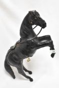 A vintage leather horse, having glass eyes and brass stirrups.
