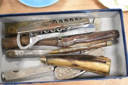 A selection of vintage knives and bottle openers, including horn handled and advertising examples