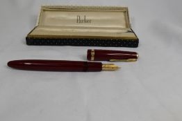 A boxed Parker Duofold Maxima aeromatic fill fountain pen in red, having broad decorative band to