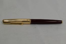 A Parker 65 aeromatic fountain pen in burgundy having rolled gold cap with Parker 14k nib. Approx