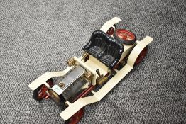 A Mamod Live Steam Roadster in cream with black seats and red trim