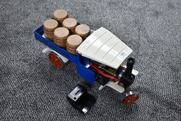 A Mamod Live Steam Wagon having blue body, white roof and red trim, with 6 barrel load