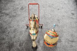 A tin plate Triang style push along Horse having painted decoration along with a tinplate Spinning