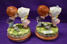 A pair of mid-century pottery figurines in the manner of Hummel, two kissing children with