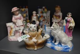 A collection of Victorian Fairings and porcelain figures including a nude piano baby.