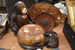 A wooden cat and teddy bear with an Indonesian style mask and a wooden snack tray.