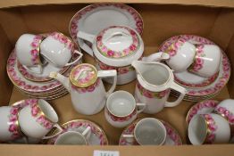 An Early 20th century part tea service un marked in porcelain decorated with roses.