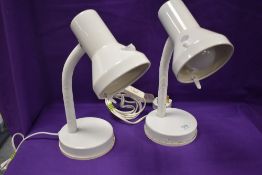 A pair of modern goose neck side lamps.