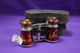 A pair of early 20th century opera glasses having painted metal frames with case.