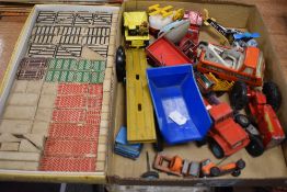 A box of vintage play worn die cast toys with a building block set.