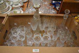 Two cut glass decanters and a collection of assorted cut glass drinking glasses.