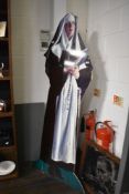 A life size cardboard nun, mounted on thick board.