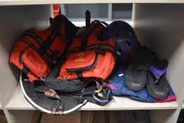 A life jacket, a pair of water shoes, helmet and similar water sports items.