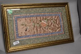 A framed and glazed Chinese embroidery having bird and blossom depicted in silk thread to centre.
