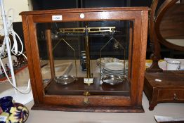 An early 20th century Griffin and Tatlock Chemist or Apothecary scales in a fitted oak and glass