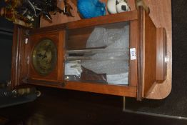 An early 20th century Vienna style wall clock having a glass and mahogany case.