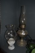 An early 20th century table top oil lamp with chimney and a marble based candle holder with shade.