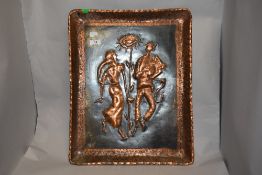 An embossed and etched copper wall plaque, depicting traditionally attired figures to centre.