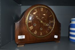 A 1930s Smiths hump backed mantel clock, having Roman numerals to face with decorative filigree