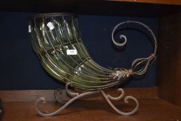 A vintage green glass Cornucopia shaped centre piece, supported by scrolled metal frame.