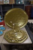 An antique Indian brass table top tray with two similar brass trays.