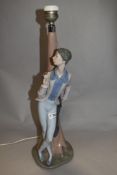 A Nao by Lladro lamp base of a Romeo style lover with rose leaning against a tree, 45cm tall.