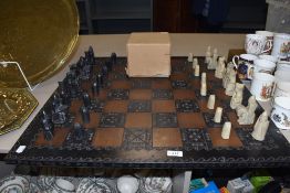 A mid century style chess set in an Isle of Lewis style with large wooden board.
