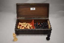 An intricately carved wooden box having floral decoration to lid and sides, housing a collection