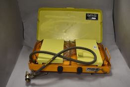 A vintage 1960s camping gas stove in yellow and orange.