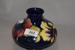 A mid century Moorcroft vase of squat baluster from, having tube lined hibiscus pattern on cobalt