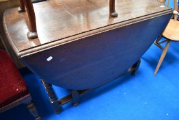 An early to mid 20th Century oak drop leaf dining table