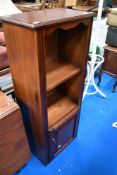 A reproduction narrow shelf with cupboard under