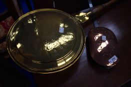 A traditional brass bed warming pan and a copper nut roaster