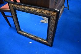 A modern ebonised and gilt effect wall mirror