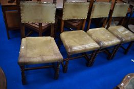 A set of four oak and leather dining chairs