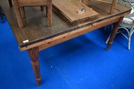A traditional kitchen table with pine frame , turned legs and later top