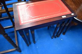 A reproduction mahogany nest of three tables