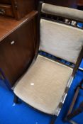 A Victorian mahogany nursing chair having spindle detailing and later dralon upholstery