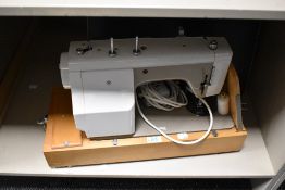 A New Home electric sewing machine with case and accessories.