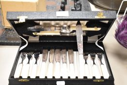 A vintage canteen of bone handled fish servers, knives and forks, having etched decoration.