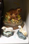 A cast iron door stop in the form of a frog and two smaller examples in the form of sheep.