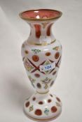 A 19th century Bohemian overlay glass vase, wheel-cut with apertures and painted with foliate