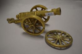 A vintage brass canon and a cartwheel.