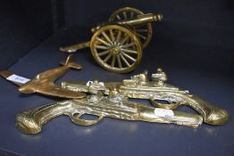 Four vintage novelty ornamental brasses, comprising; cannon, plane and two pistols.