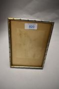 An Indian white metal photograph frame, of rectangular form with rope-twist type decoration,