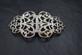 A Queen Elizabeth II silver nurses belt buckle, of typical pierced scrolling form, marks for