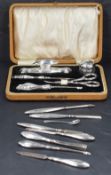 A George V silver mounted and cased manicure set, with embossed foliate decoration to the mounts,
