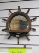 A mid century stained wood nautical mirror with shelf, in the form of a ships wheel.
